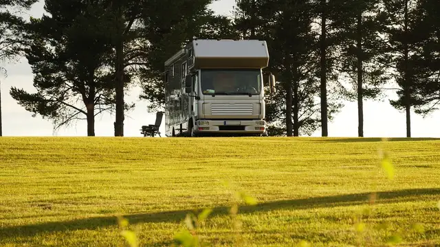 Drohnenaufnahme eines grünen Campingplatzes zwischen Bäumen