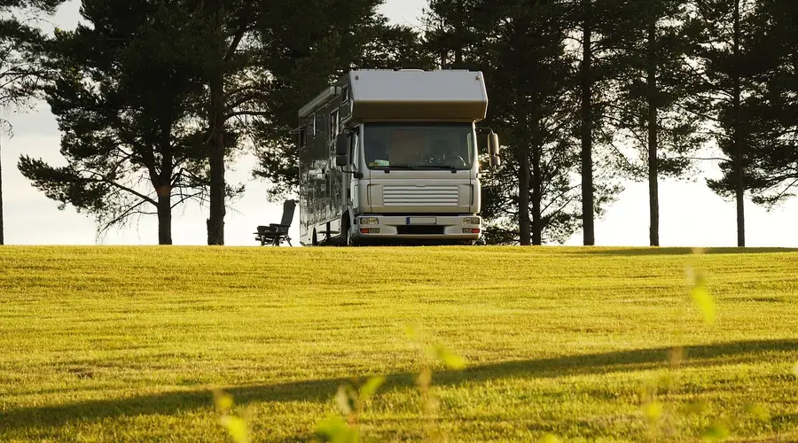 Drohnenaufnahme eines grünen Campingplatzes zwischen Bäumen