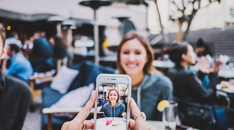 Hand hält ein Smartphone und macht ein Foto