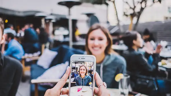 Hand hält ein Smartphone und macht ein Foto