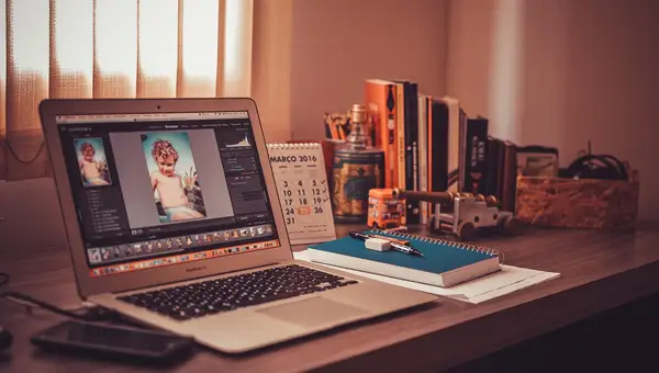 Schreibtisch mit Laptop, Wandkalender und Büchern